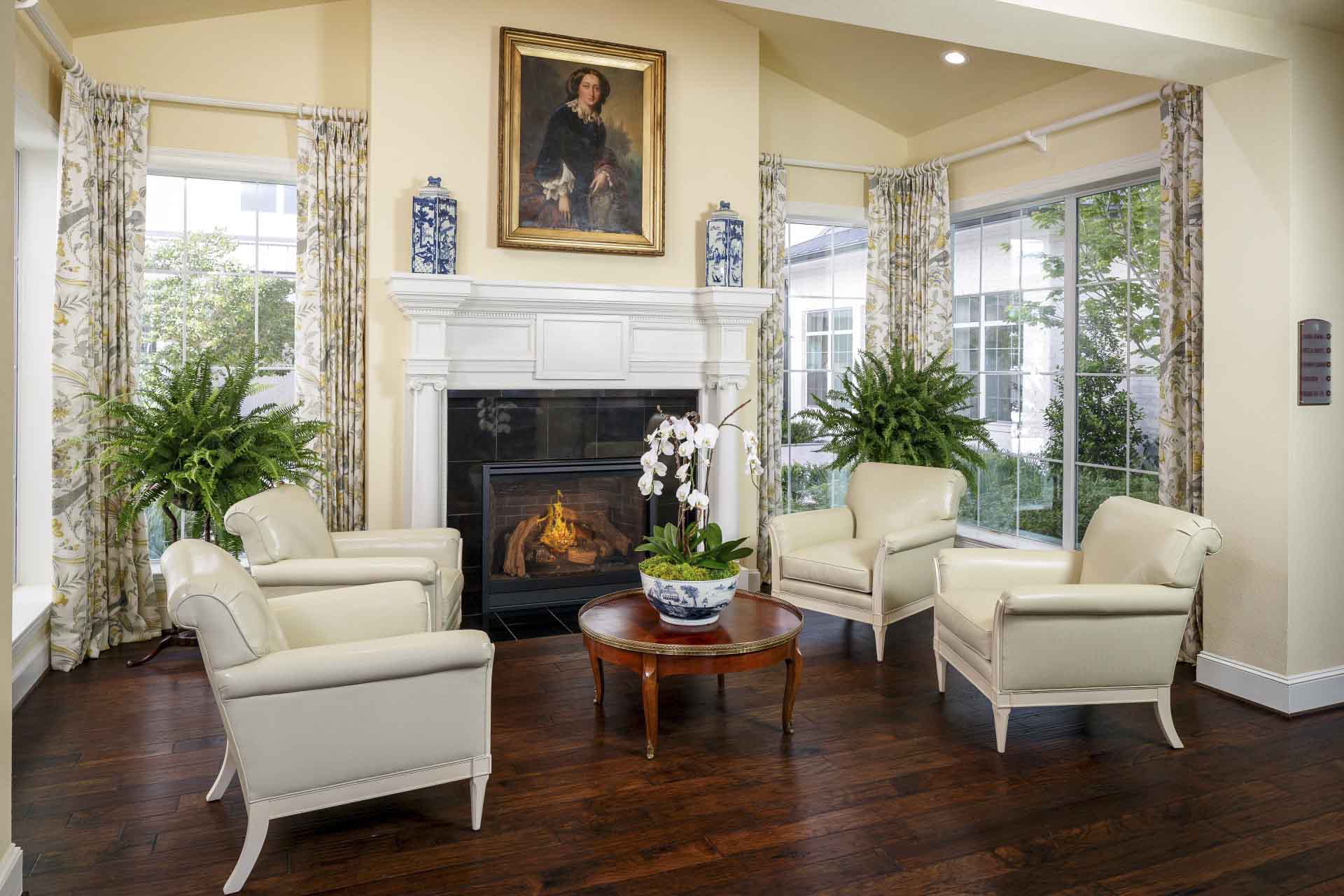A cozy sitting area, with large windows, and a fireplace at Tradition Senior Living.